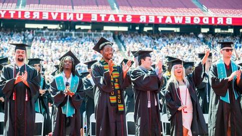 Diverse group of students clapping and cheering at the Bridgewater State University graduation